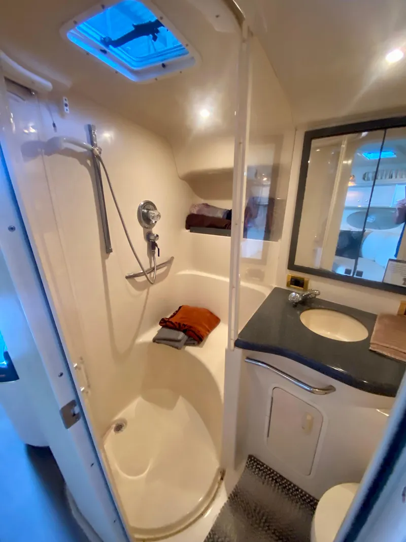Slide: The Image of 1997 Sea Ray 400 Sundancer bathroom with shower, sink, and mirror. - 29
