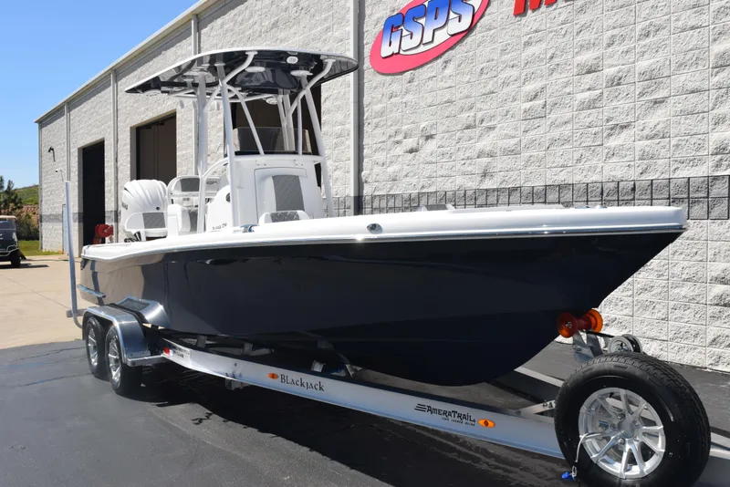 Slide: The Image of 2025 BlackJack 256 Coastal boat on trailer outside dealership. - 2