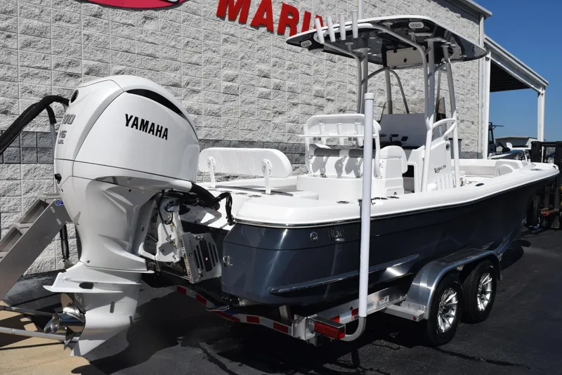 Slide: The Image of 2025 BlackJack 256 Coastal boat with Yamaha engine on trailer, parked outside a marine store. - 4