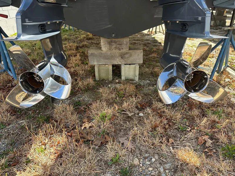 Slide: The Image of Twin propellers of 2022 Grady-White 325 Freedom boat on dry grass. - 2