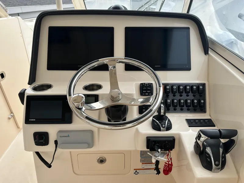 Slide: The Image of Control panel of 2022 Grady-White 325 Freedom boat with steering wheel and electronic displays. - 3
