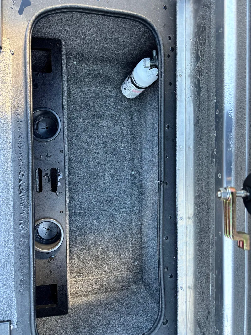 Slide: The Image of 2024 Tracker Pro Team 195 TXW Tournament Edition storage compartment with cup holders and a bottle. - 4