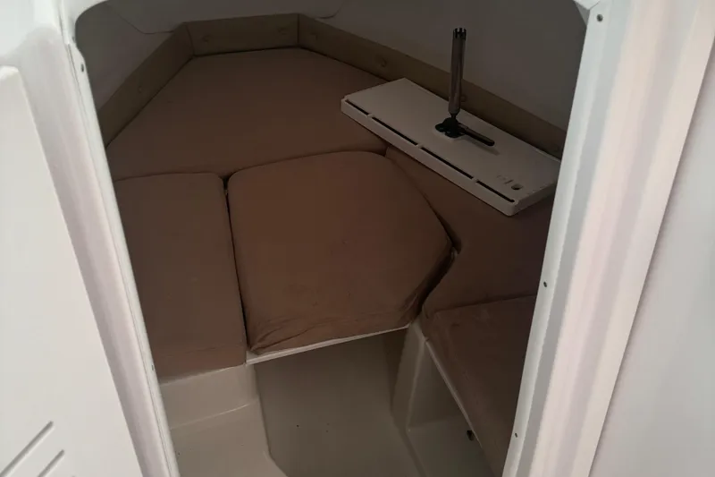 Slide: The Image of 2008 Pro-Line 23 XP boat cabin interior with beige cushions and compact table. - 8