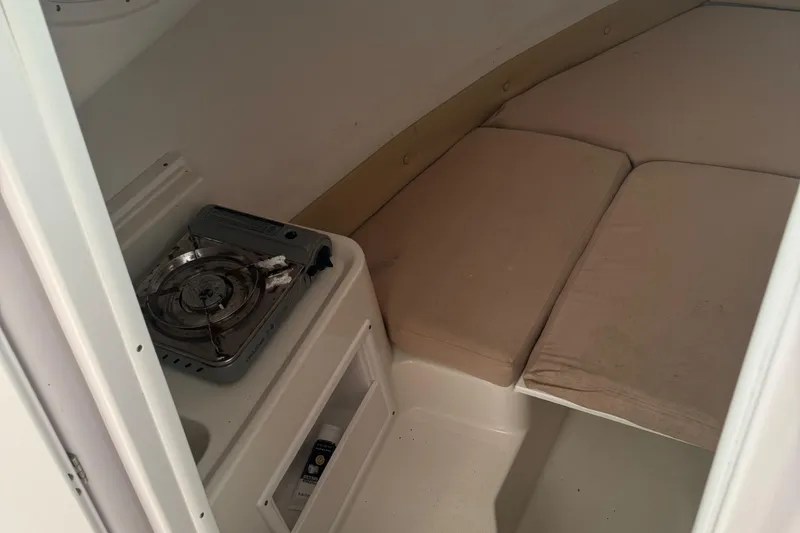 Slide: The Image of 2008 Pro-Line 23 XP boat cabin with stove and cushioned seating area. - 9