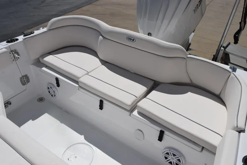 Slide: The Image of 2025 Sea Hunt Ultra 235 SE boat with white cushioned seating and storage compartments. - 10