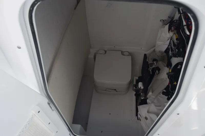 Slide: The Image of 2025 Sea Hunt Ultra 235 SE boat interior with compact marine toilet. - 16