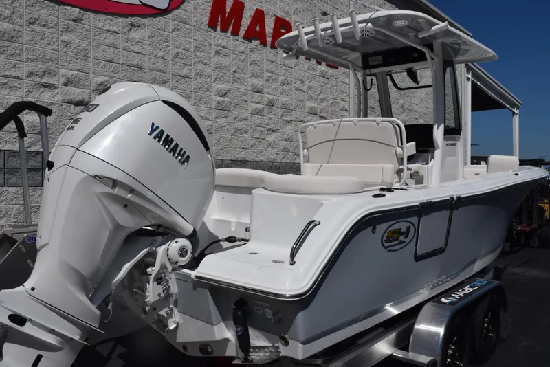 Slide: The Image of 2025 Sea Hunt Ultra 235 SE boat with Yamaha engine, parked outside a marine store. - 3