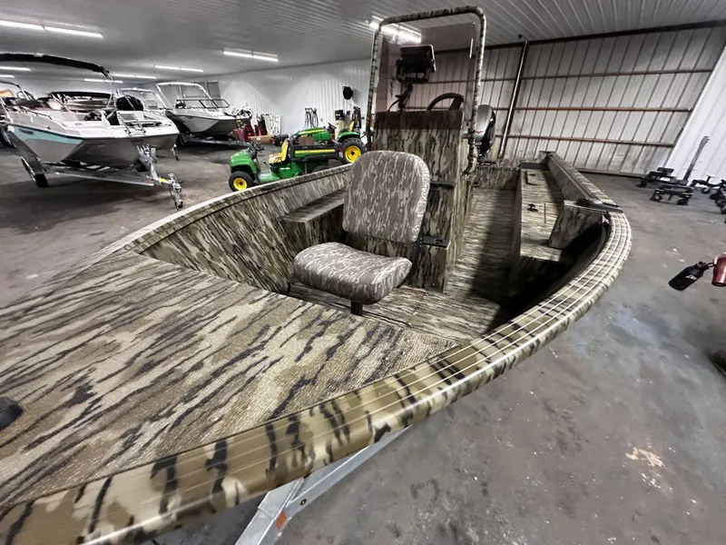Slide: The Image of 2025 Starcraft 180 Freedom CC boat with camouflage design in a storage facility. - 1
