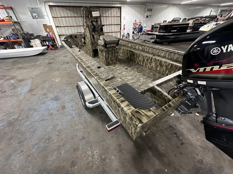 Slide: The Image of 2025 Starcraft 180 Freedom CC boat in a garage with Yamaha outboard motor. - 2