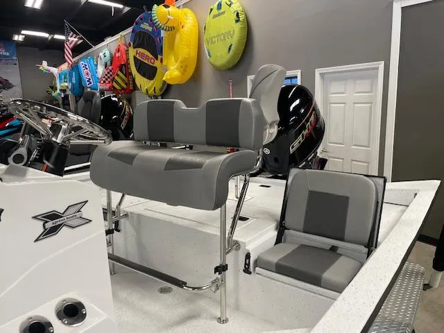 Slide: The Image of 2025 Xpress Hyper Lift H20 Bay boat interior with gray seating and steering wheel. - 6