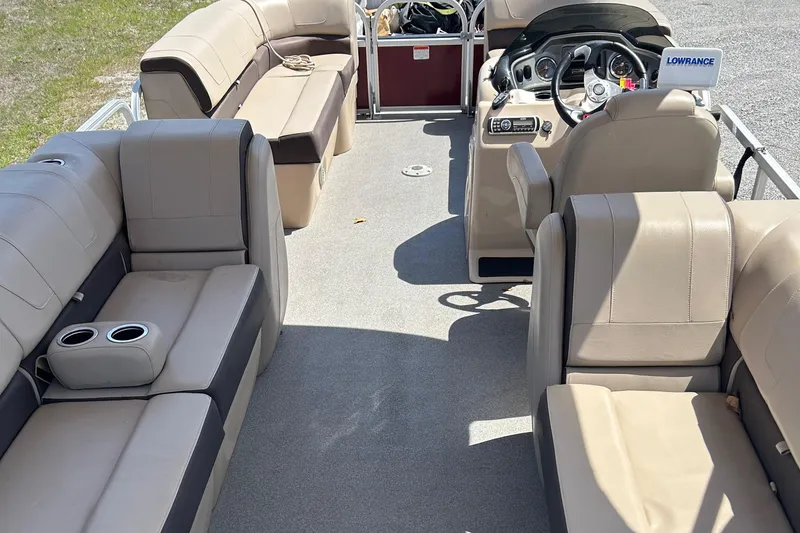 Slide: The Image of 2018 Sun Tracker Party Barge 22 DLX XP3 interior with beige seating and steering console. - 12