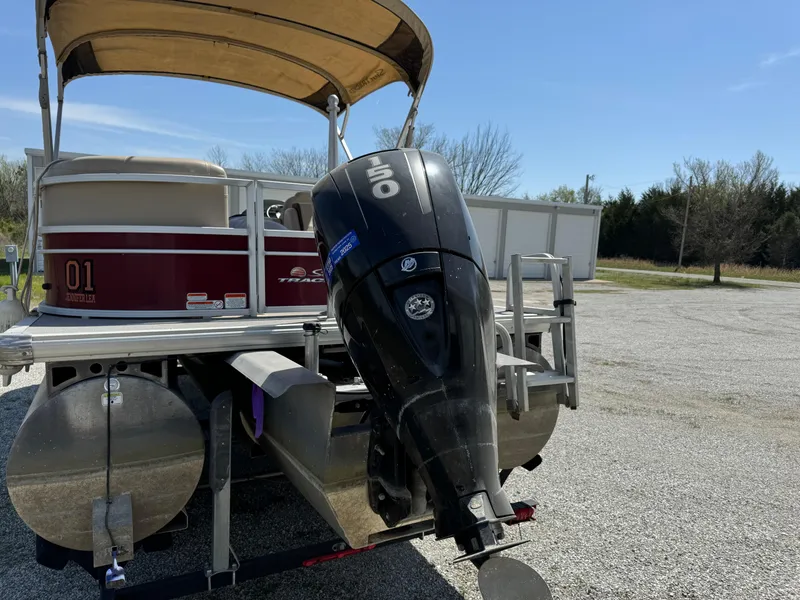 Slide: The Image of 2018 Sun Tracker Party Barge 22 DLX XP3 with outboard motor, parked on gravel. - 3