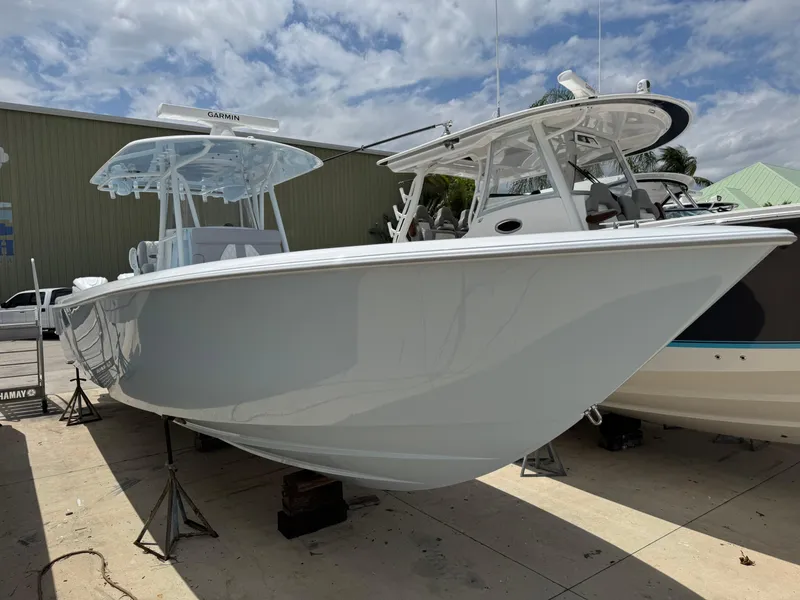The Image of 2025 Contender 35 ST boat displayed outdoors on stands under a partly cloudy sky. - 1