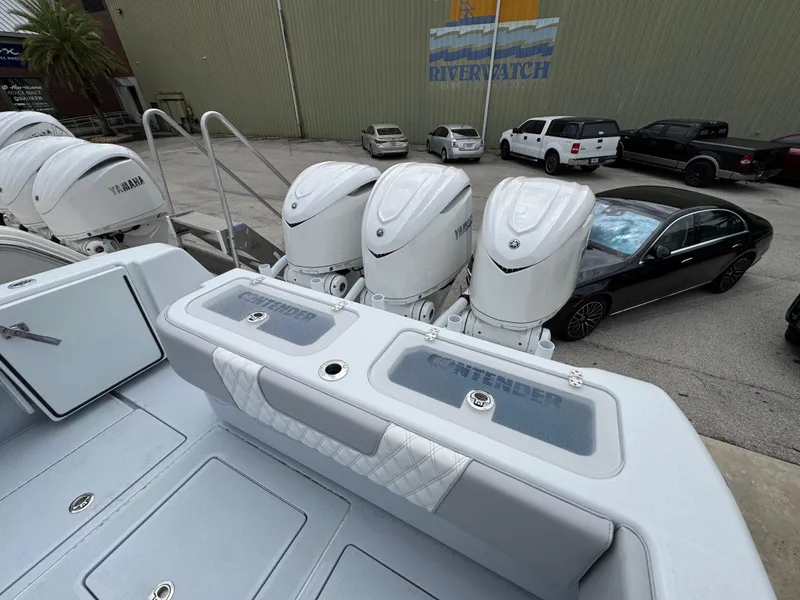 Slide: The Image of 2025 Contender 35 ST boat with Yamaha engines, parked near a warehouse. - 2