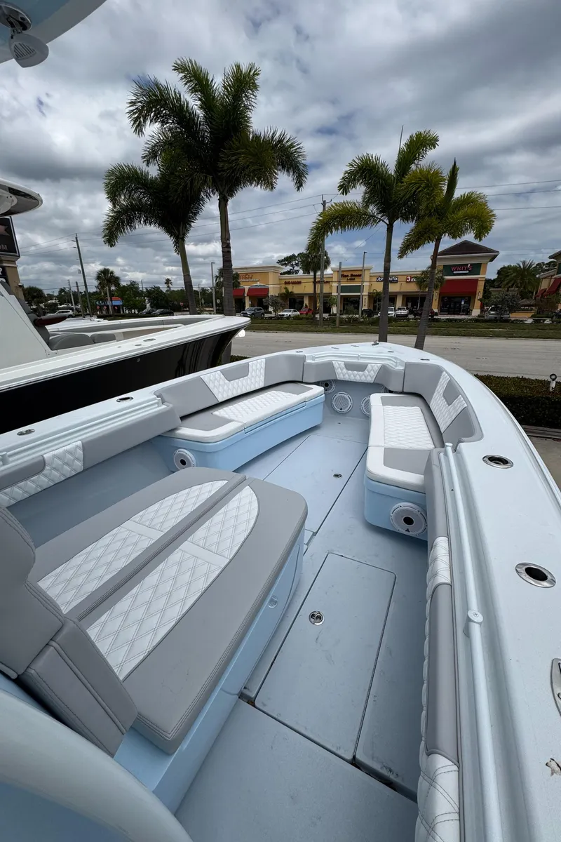 Slide: The Image of 2025 Contender 35 ST boat interior with cushioned seating, set against a tropical backdrop. - 7