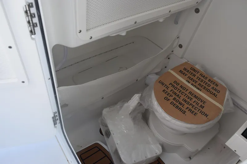 Slide: The Image of Interior of 2025 Sea Hunt Ultra 255 SE boat with toilet and storage area. - 14