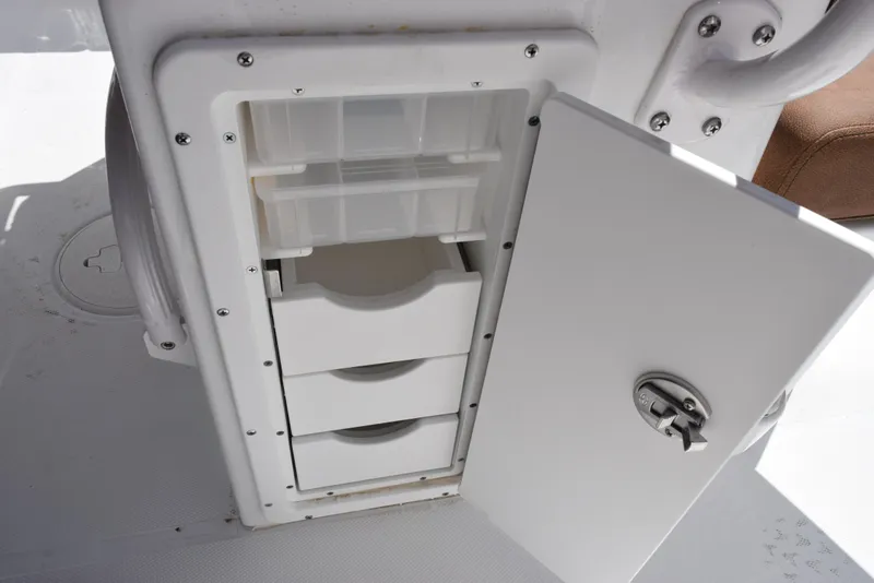 Slide: The Image of Open storage compartment on 2025 Sea Hunt Ultra 255 SE boat, featuring organized drawers. - 15