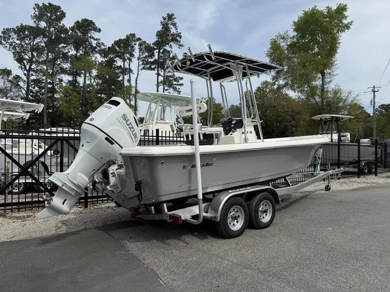 Slide: The Image of 2025 Bulls Bay 2200 XS boat on trailer with Suzuki outboard motor, parked outdoors. - 3