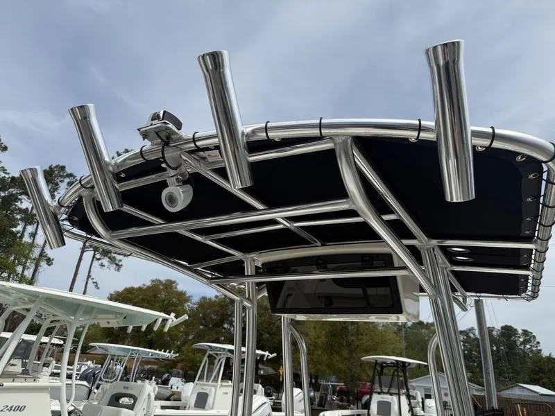 Slide: The Image of 2025 Bulls Bay 2200 XS boat with T-top and rod holders in a marina setting. - 9