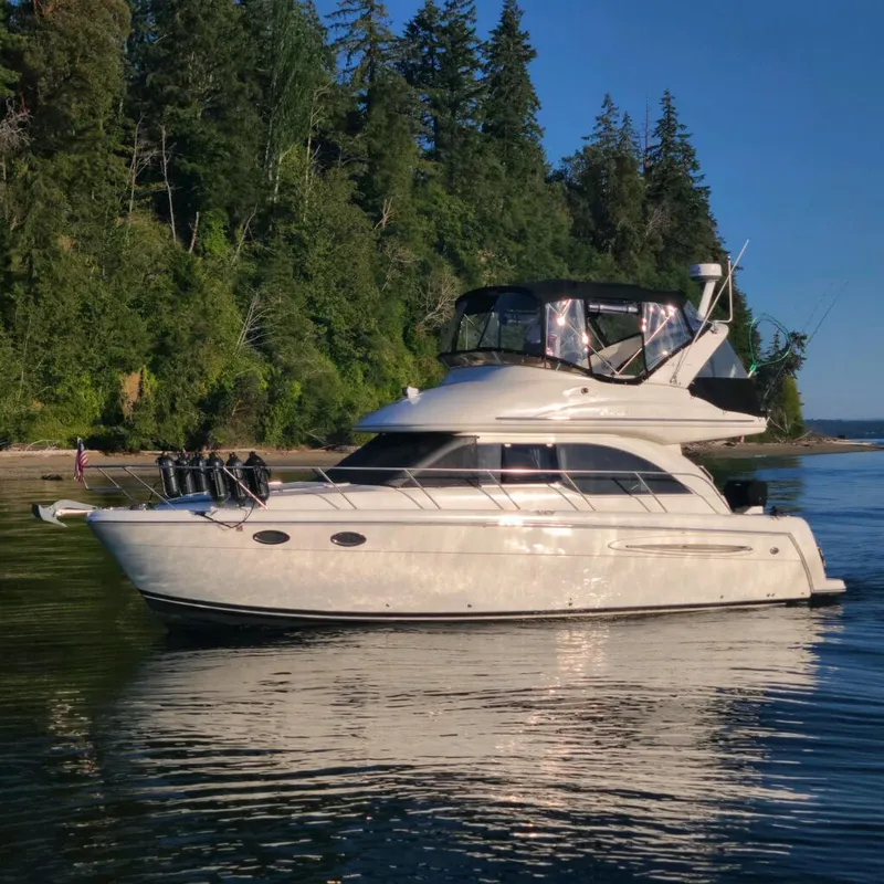 The Image of 2004 Meridian 341 yacht on calm water near a forested shoreline. - 0