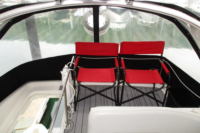 Slide: The Image of Red chairs on 2004 Meridian 340 boat deck with clear canopy. - 19