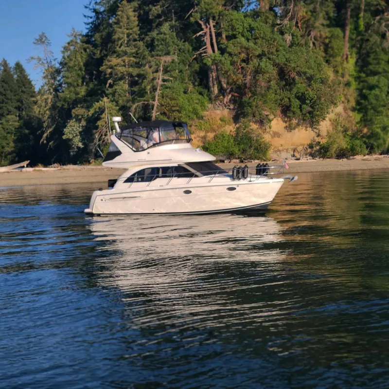 Slide: The Image of 2004 Meridian 341 yacht on calm water near a forested shoreline. - 2