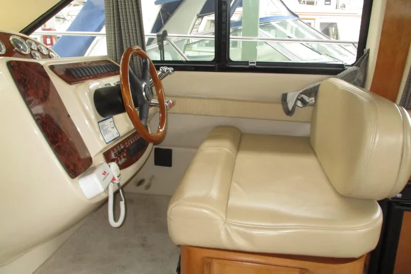 Slide: The Image of 2004 Meridian 340 helm with beige leather seat and wooden steering wheel. - 21