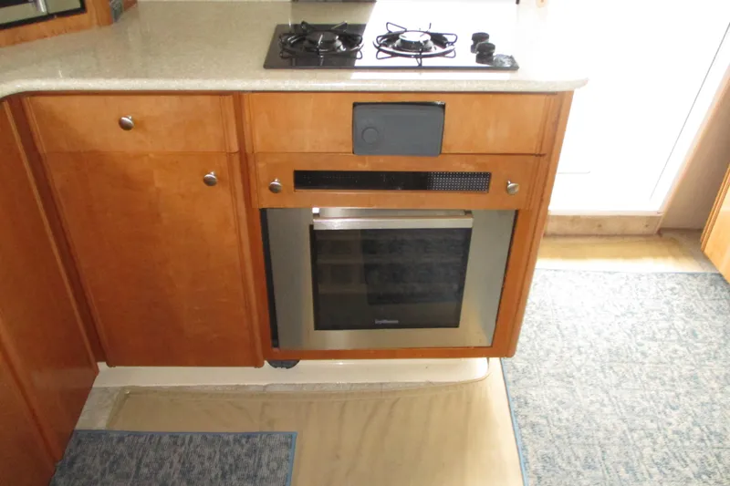 Slide: The Image of 2004 Meridian 340 kitchen with stove and oven, featuring wooden cabinetry and countertop. - 24