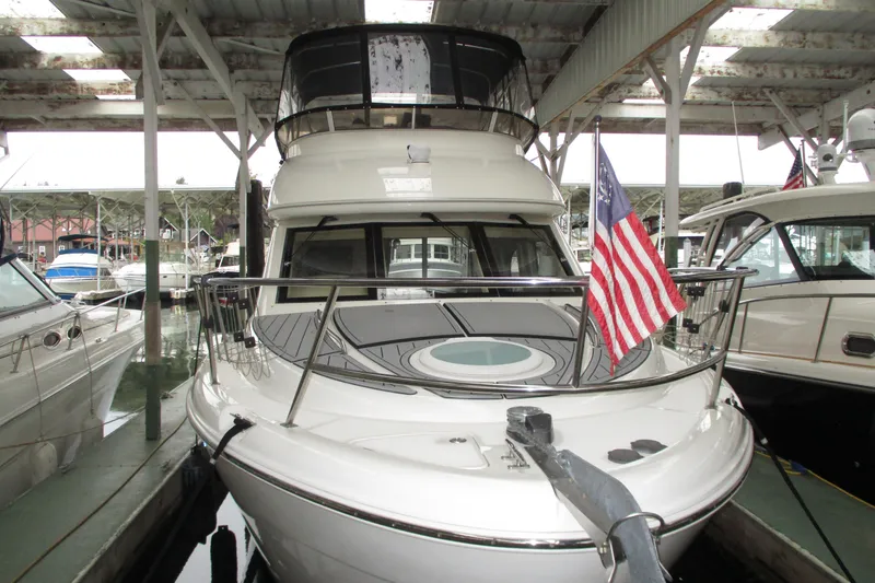 Slide: The Image of 2004 Meridian 340 yacht docked, displaying an American flag, under a covered marina. - 6