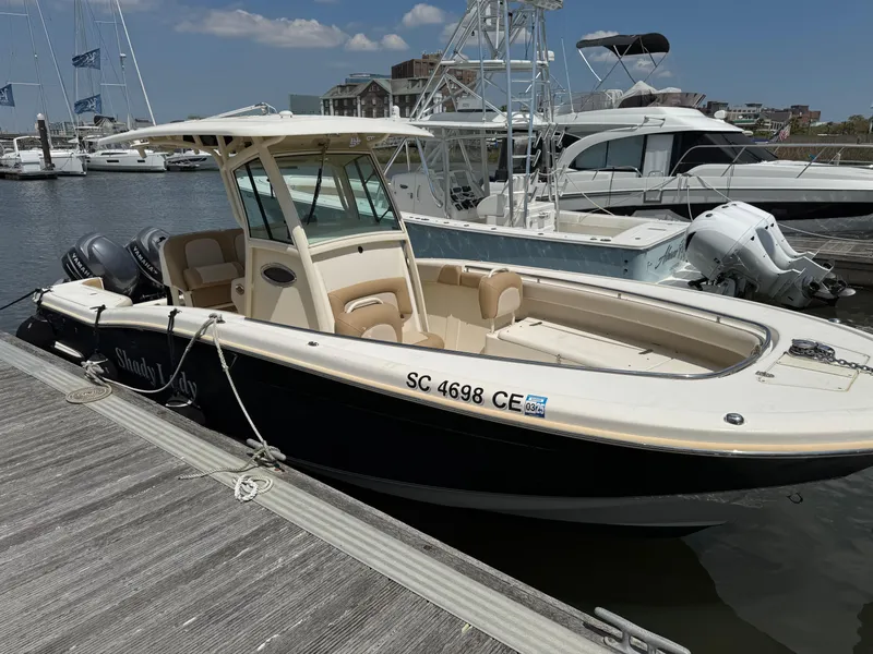 Slide: The Image of 2012 Scout 262 XSF boat docked at marina, featuring sleek design and spacious seating. - 0