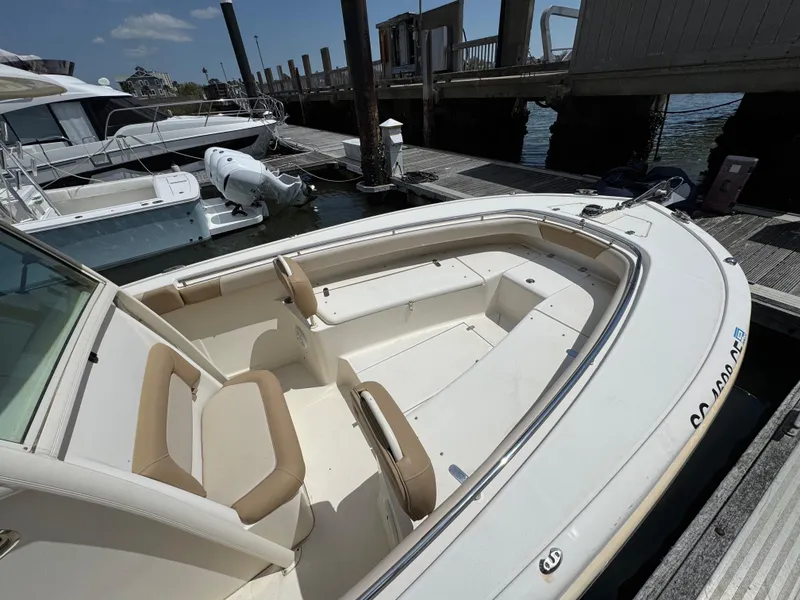 Slide: The Image of 2012 Scout 262 XSF boat docked at marina, featuring spacious seating and sleek design. - 10