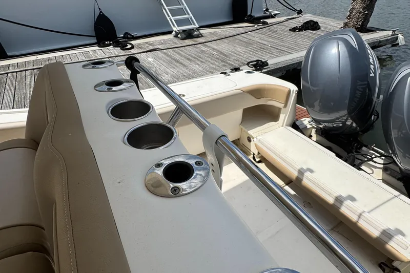 Slide: The Image of 2012 Scout 262 XSF boat interior with rod holders and twin engines at dock. - 16