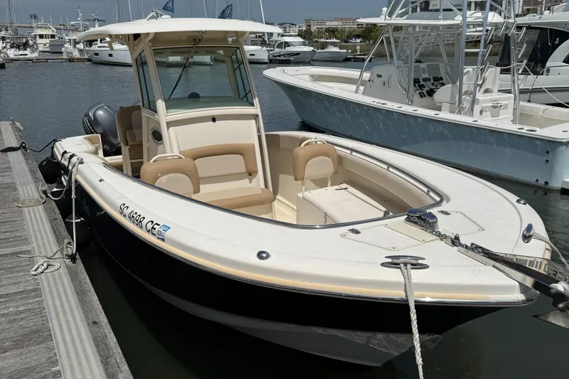 Slide: The Image of 2012 Scout 262 XSF boat docked at marina, featuring sleek design and comfortable seating. - 2