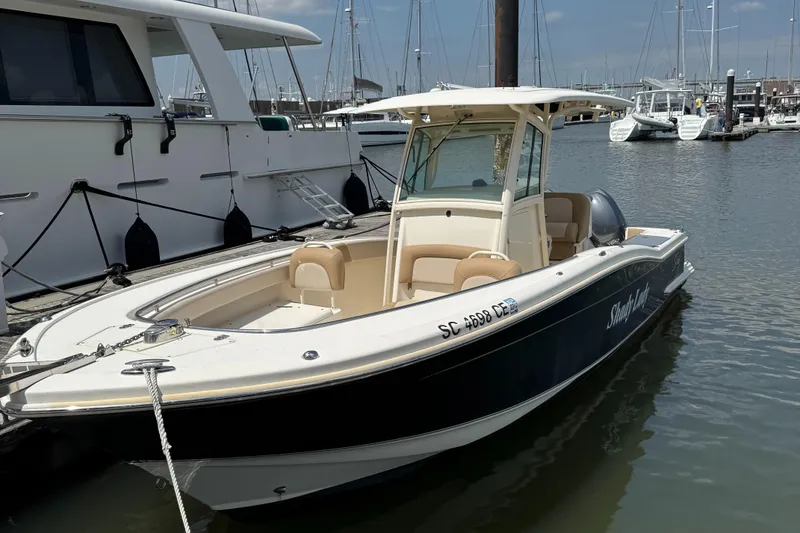 Slide: The Image of 2012 Scout 262 XSF boat docked in marina, featuring sleek design and spacious seating. - 3