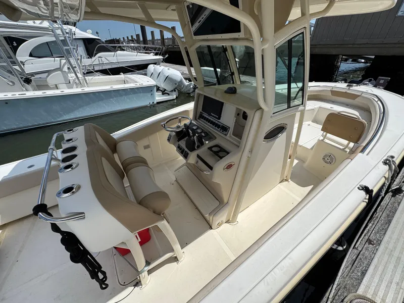 Slide: The Image of 2012 Scout 262 XSF boat interior with helm, seating, and docked at marina. - 6