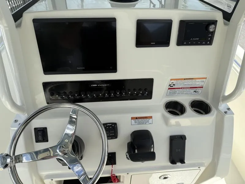 Slide: The Image of 2025 Cobia 240 Center Console dashboard with steering wheel, controls, and electronic displays. - 10