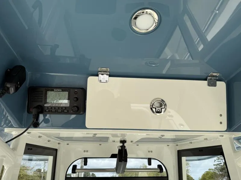 Slide: The Image of 2025 Cobia 240 Center Console boat interior with radio and storage compartment. - 11