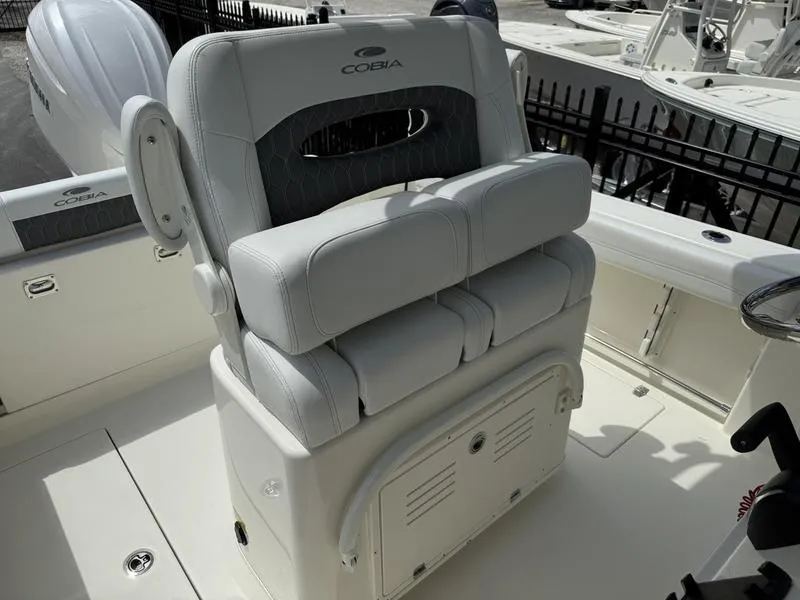 Slide: The Image of 2025 Cobia 240 Center Console boat seat, white upholstery, outdoor setting. - 12