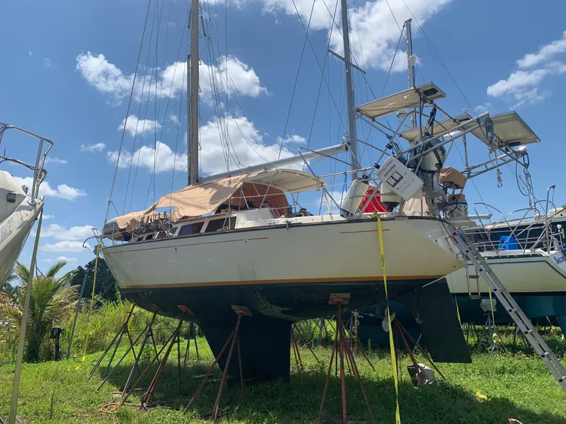Slide: The Image of 1981 S2 11A sailboat on stands, under a clear blue sky. - 1