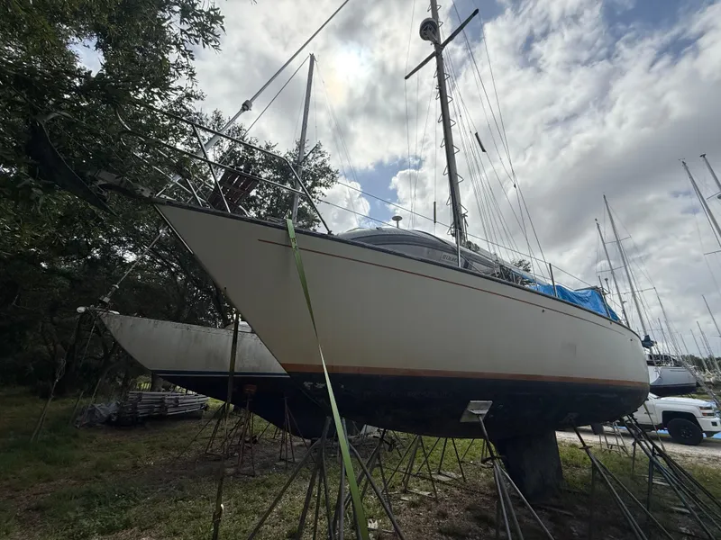 Slide: The Image of 1981 S2 11A sailboat on stands, cloudy sky background. - 11