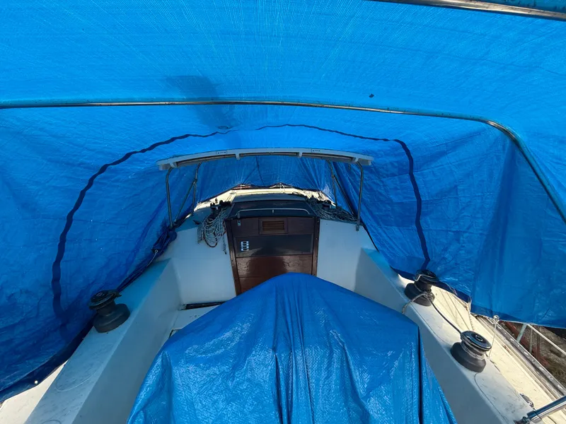 Slide: The Image of 1981 S2 11A sailboat cockpit covered with blue tarps for protection. - 12