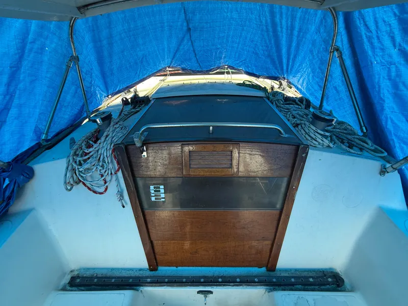 Slide: The Image of 1981 S2 11A sailboat cockpit with blue tarp and wooden hatch. - 17