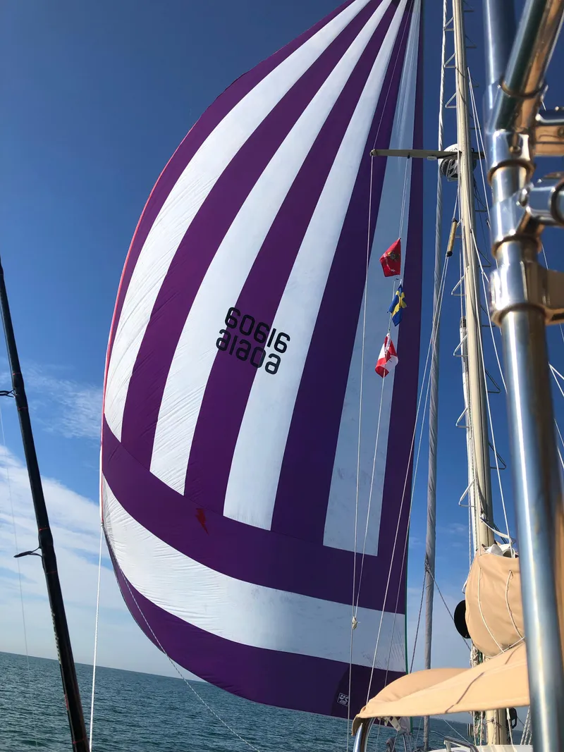 Slide: The Image of Sailboat with purple and white spinnaker, S2 11A model, 1981, sailing on open water. - 2