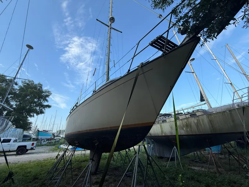 Slide: The Image of Sailboat S2 11A 1981 on stands in a boatyard under a clear blue sky. - 25