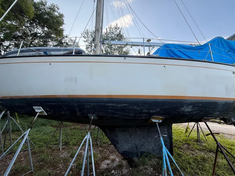 Slide: The Image of 1981 S2 11A sailboat on stands, partially covered, with visible keel and mast. - 29