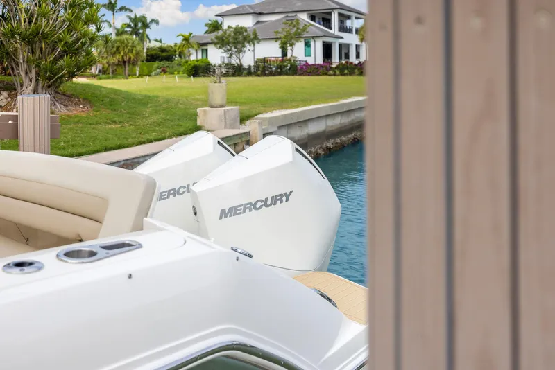 Slide: The Image of 2022 Boston Whaler 320 Vantage with Mercury engines docked near a waterfront home. - 10