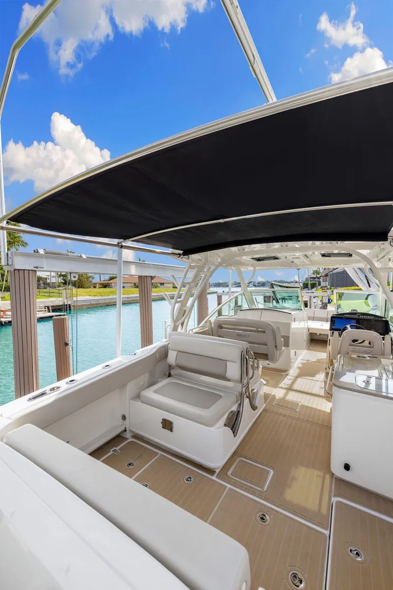 Slide: The Image of 2022 Boston Whaler 320 Vantage boat interior with seating, under a sunny sky. - 15