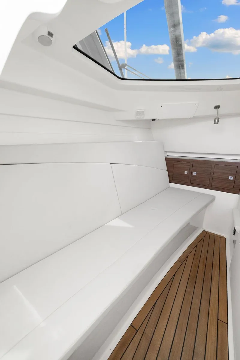 Slide: The Image of 2022 Boston Whaler 320 Vantage interior with sleek seating and wooden flooring. - 18