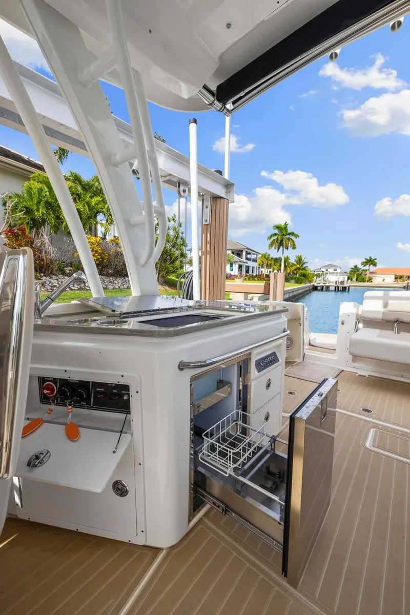Slide: The Image of 2022 Boston Whaler 320 Vantage boat interior with open storage, dockside view, and clear blue sky. - 20