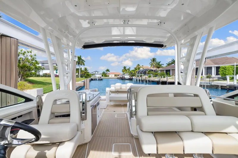 Slide: The Image of 2022 Boston Whaler 320 Vantage boat interior with luxurious seating and waterfront view. - 21